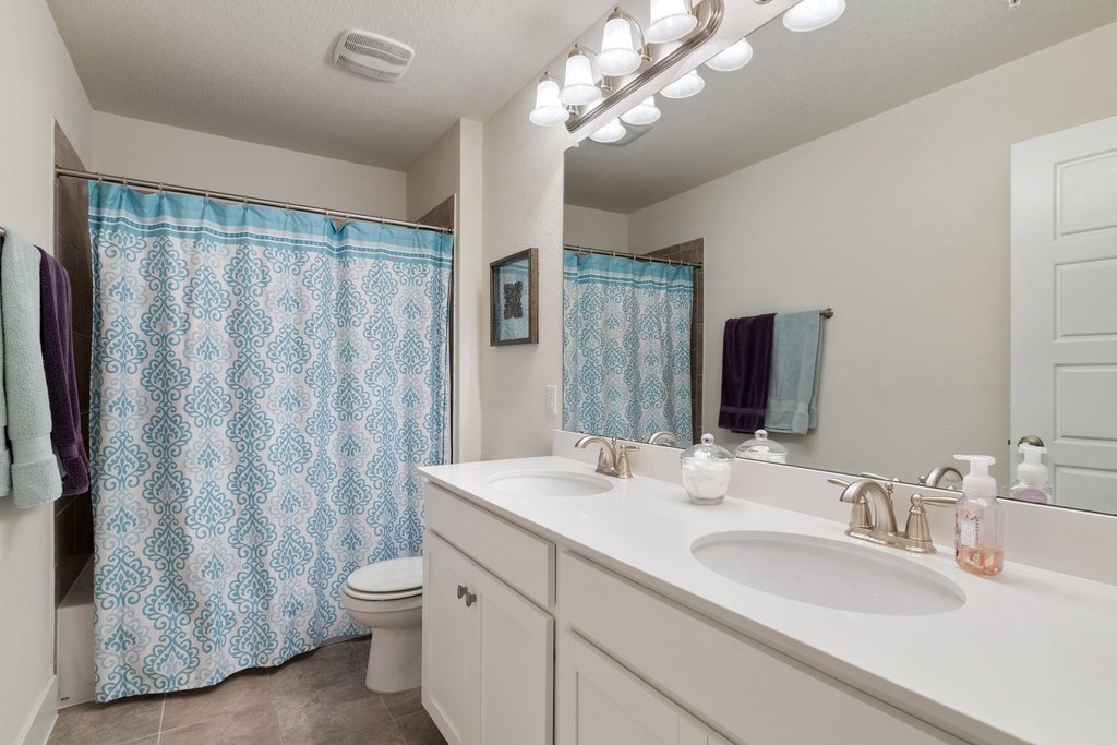 7409 Merrick Lane, Unit 40 Austin, TX 78745 - Photo 26 of 37 a bathroom with a granite countertop sink a toilet and a mirror