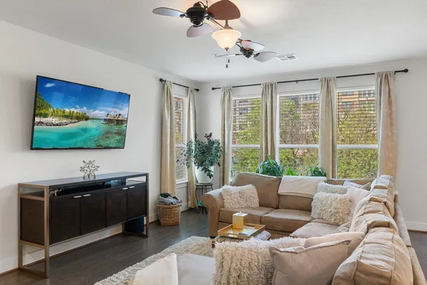 a living room with furniture wooden floor and windows