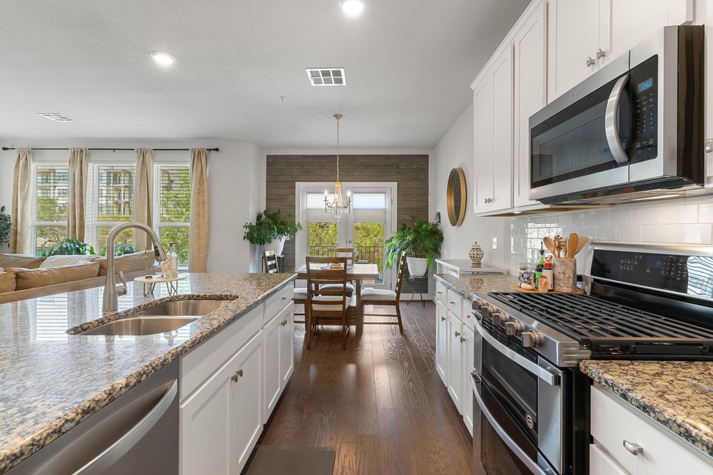 7409 Merrick Lane, Unit 40 Austin, TX 78745 - Photo 37 of 37 a kitchen with stainless steel appliances granite countertop a stove a sink and a microwave