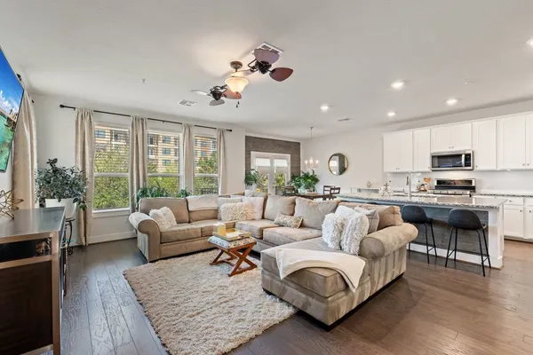 a living room with furniture large window and flat screen tv