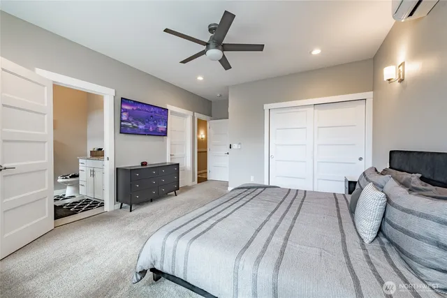 a spacious bedroom with a bed and a ceiling fan