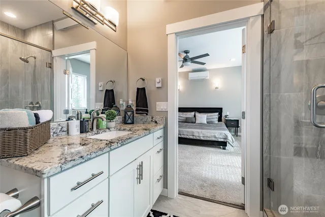 a en suite bathroom with a granite countertop sink and a mirror