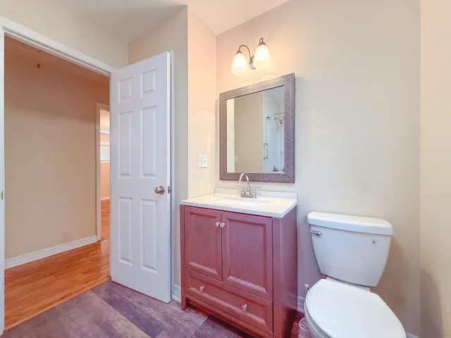 a bathroom with a toilet a sink and mirror