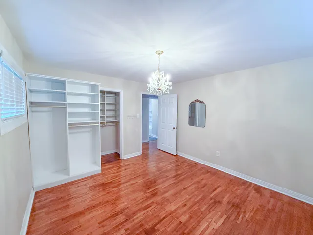 a view of a room with wooden floor staircase and a kitchen