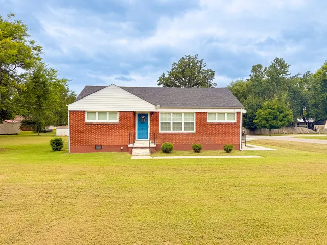 a front view of a house with yard and swimming pool