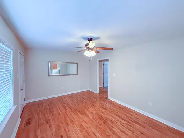 a view of empty room with wooden floor