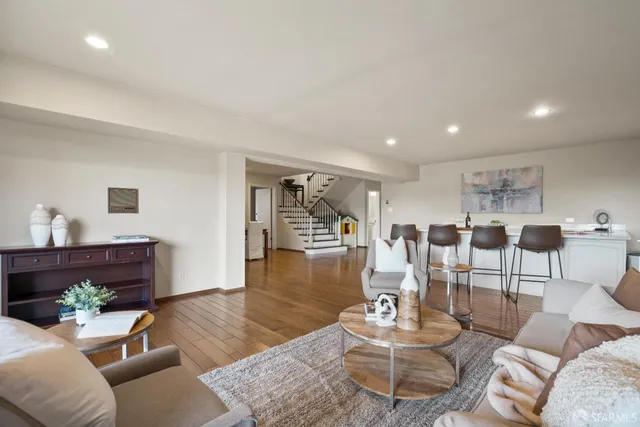 a living room with furniture and wooden floor