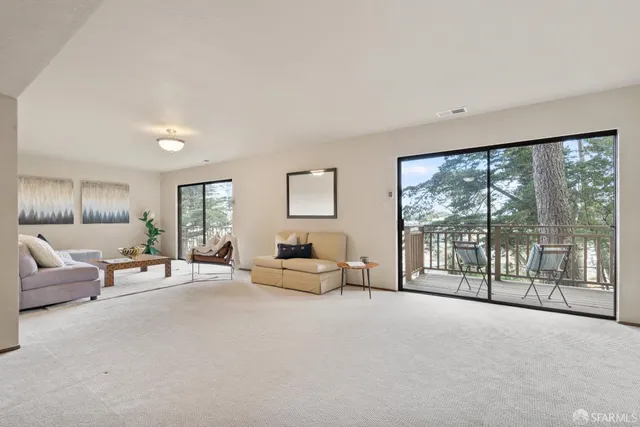 a living room with furniture and large windows