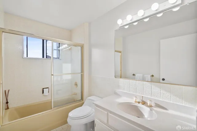 a bathroom with a sink toilet vanity and shower