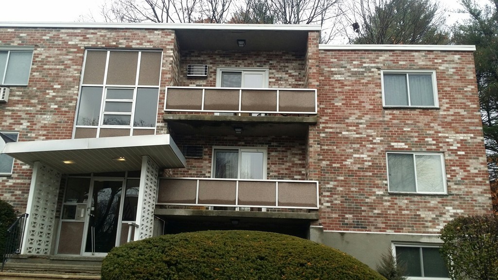 11 Jacqueline Road, Unit D Waltham, MA 02452 - Photo 2 of 13 a front view of a house with a garage