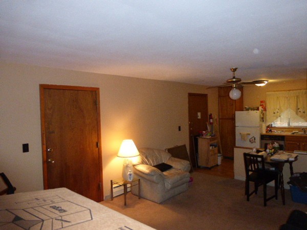 11 Jacqueline Road, Unit D Waltham, MA 02452 - Photo 5 of 13 a living room with furniture and a dining table with chandelier