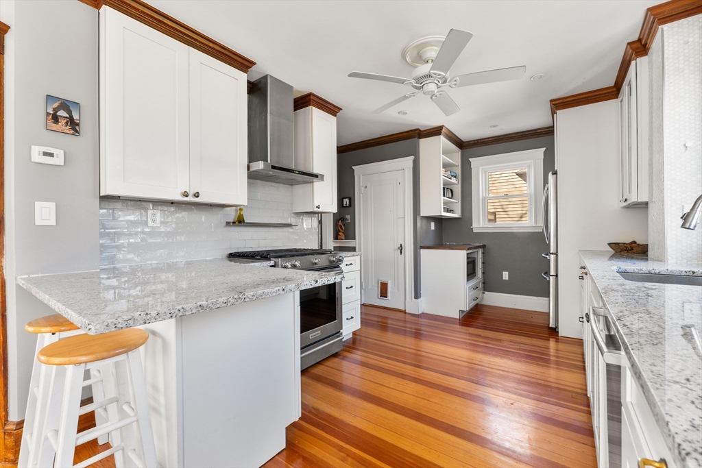 136 Beech Street Boston, MA 02131 - Photo 16 of 40 a kitchen with granite countertop a stove a sink and a refrigerator