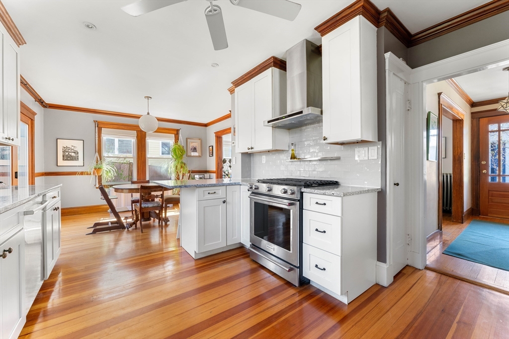 136 Beech Street Boston, MA 02131 - Photo 17 of 40 a kitchen with stainless steel appliances granite countertop wooden floors a stove and a refrigerator