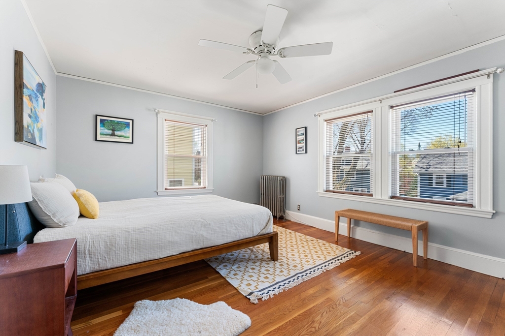 136 Beech Street Boston, MA 02131 - Photo 21 of 40 a bedroom with a bed and wooden floor