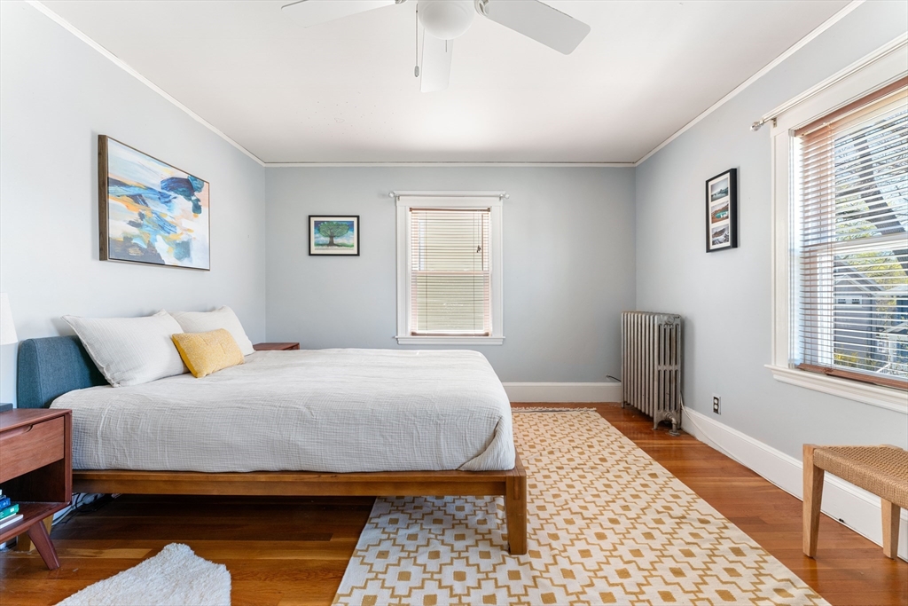 136 Beech Street Boston, MA 02131 - Photo 22 of 40 a bedroom with a bed and wooden floor