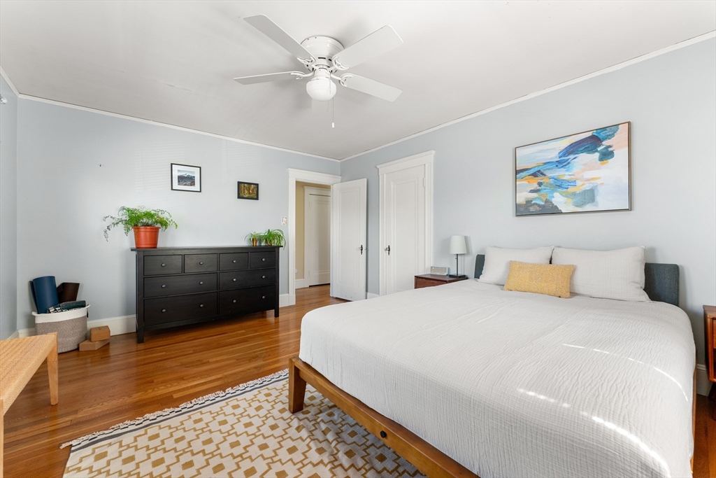 136 Beech Street Boston, MA 02131 - Photo 24 of 40 a bedroom with a bed and a chandelier