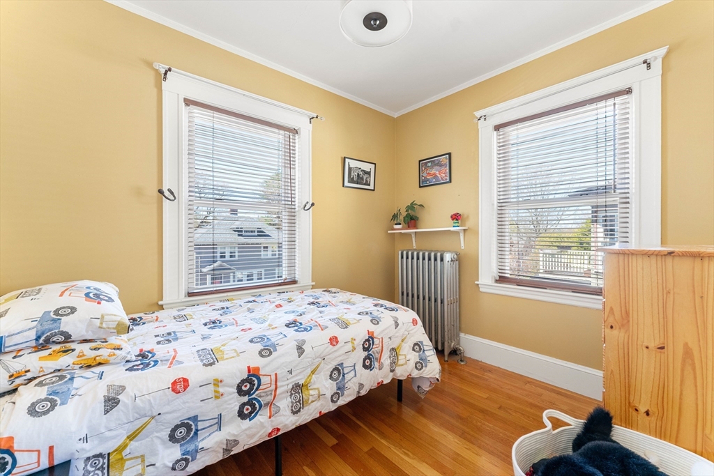 136 Beech Street Boston, MA 02131 - Photo 30 of 40 a bedroom with a bed and wooden floor