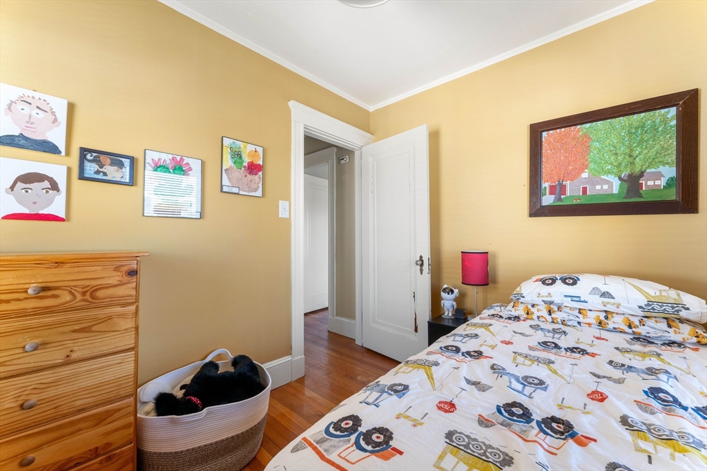 136 Beech Street Boston, MA 02131 - Photo 32 of 40 a bedroom with a bed and wooden floor