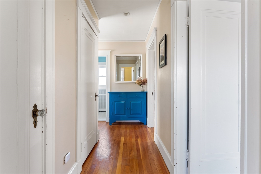 136 Beech Street Boston, MA 02131 - Photo 33 of 40 a view of a hallway with wooden floor and a bathroom