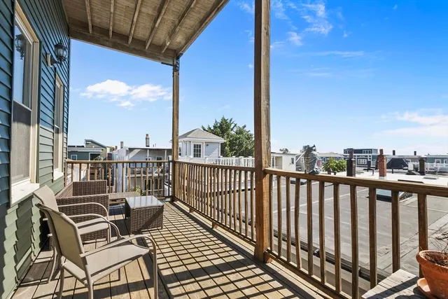 a view of balcony with wooden floor and seating space