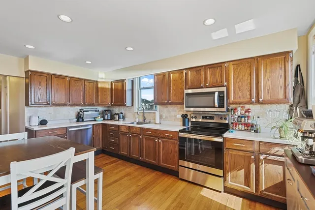 a kitchen with stainless steel appliances granite countertop wooden cabinets a stove top oven a sink and dishwasher