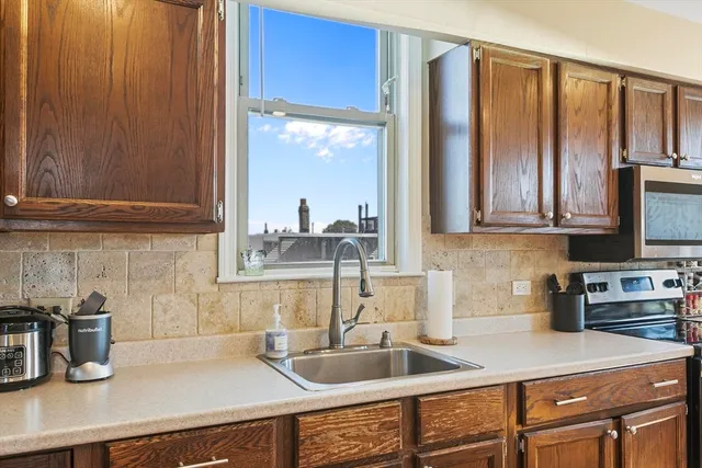 a kitchen with granite countertop a sink stove and cabinets
