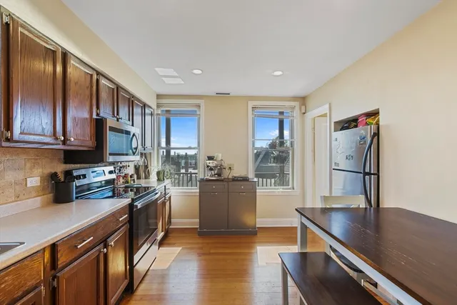 a kitchen with a refrigerator and a stove top oven