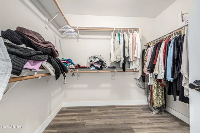 a view of walk in closet with clothes and shoes