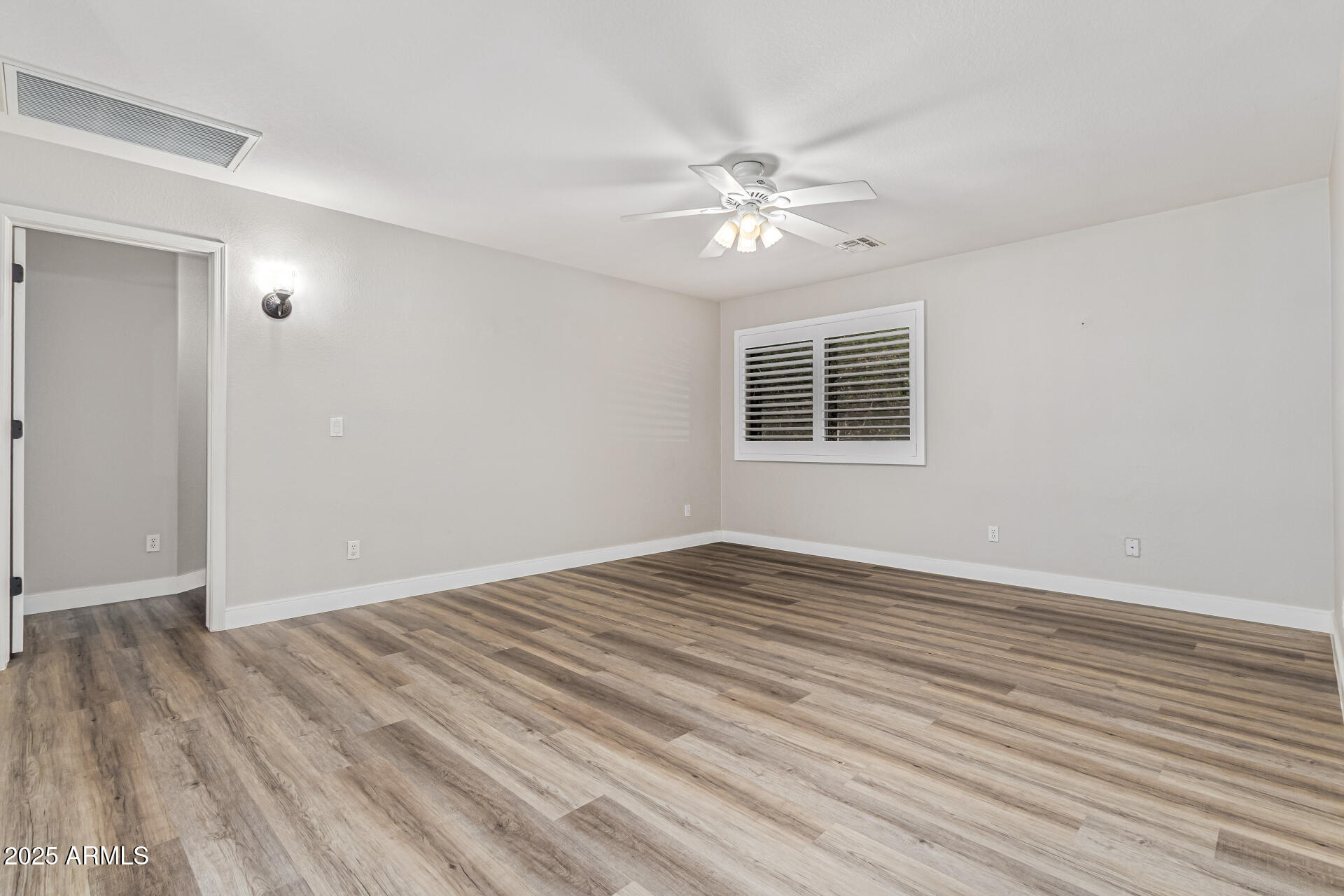 1038 East Harrison Court Gilbert, AZ 85295 - Photo 21 of 27 a view of an empty room with wooden floor and a window