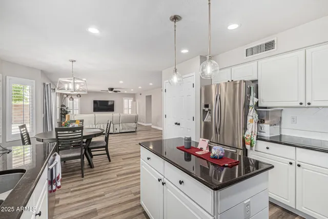 a kitchen with stainless steel appliances kitchen island granite countertop a stove and white cabinets
