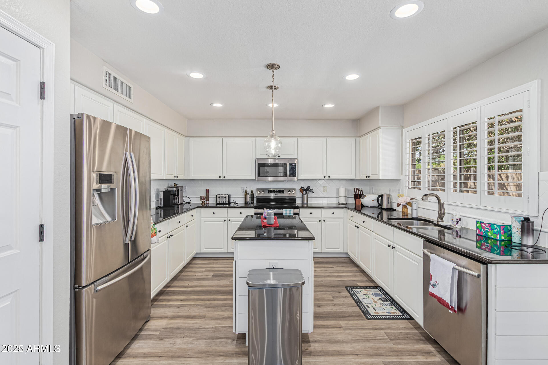 1038 East Harrison Court Gilbert, AZ 85295 - Photo 10 of 27 a kitchen with stainless steel appliances granite countertop a refrigerator sink and white cabinets