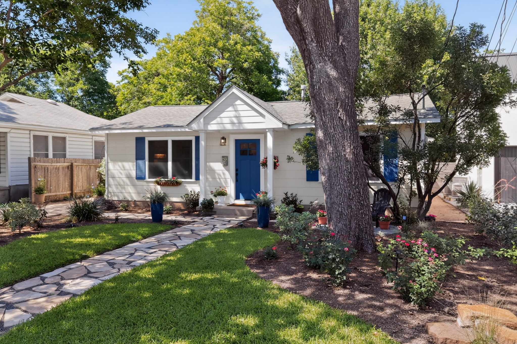 1906 Collier Street Austin, TX 78704 - Photo 33 of 40 A charming exterior with a natural stone pathway leading to the front door, nestled among mature trees and vibrant landscaping.