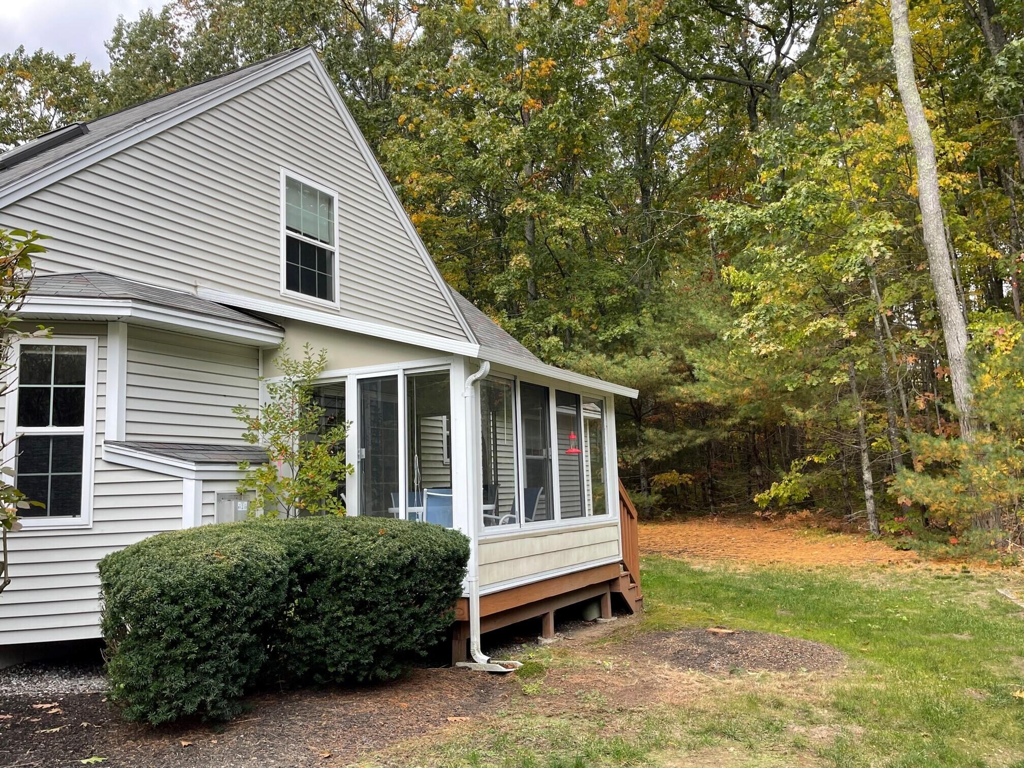 19 Windsor Commons Drive, Unit 19 Kennebunk, ME 04043 - Photo 61 of 68 Sunroom with woods behind