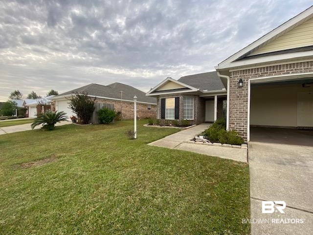 22713 Respite Lane Foley, AL 36535 - Photo 33 of 35 Exterior space featuring a garage and a lawn
