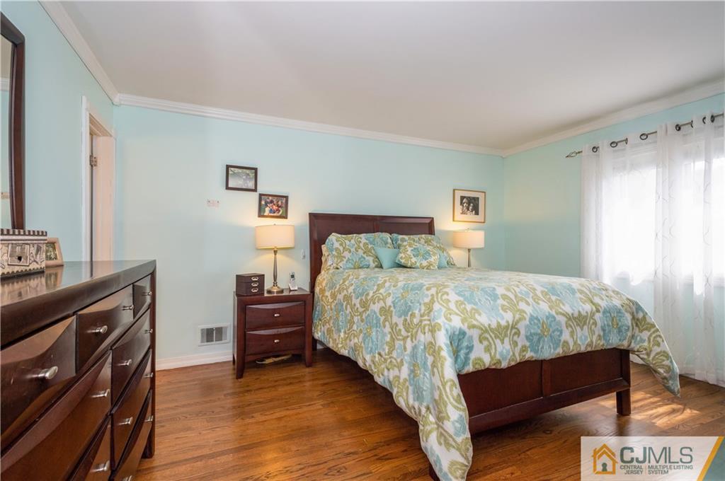 70 Wilk Road Edison, NJ 08837 - Photo 13 of 24 a bedroom with a bed and a flat tv screen on a dresser