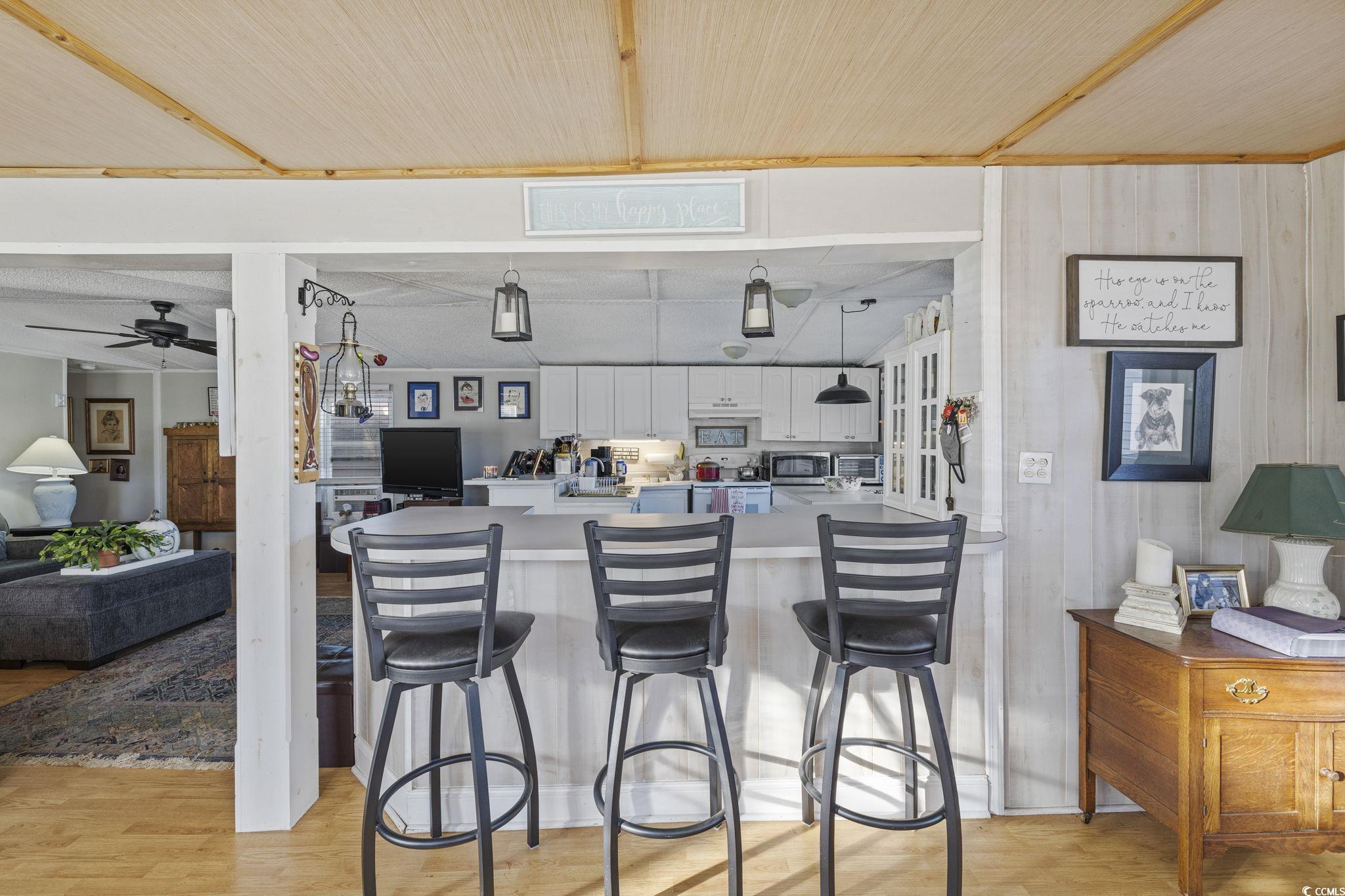 80 Princess Drive North Myrtle Beach, SC 29582 - Photo 27 of 27 Kitchen featuring a peninsula, light wood-style flooring, white cabinetry, a breakfast bar, and open floor plan