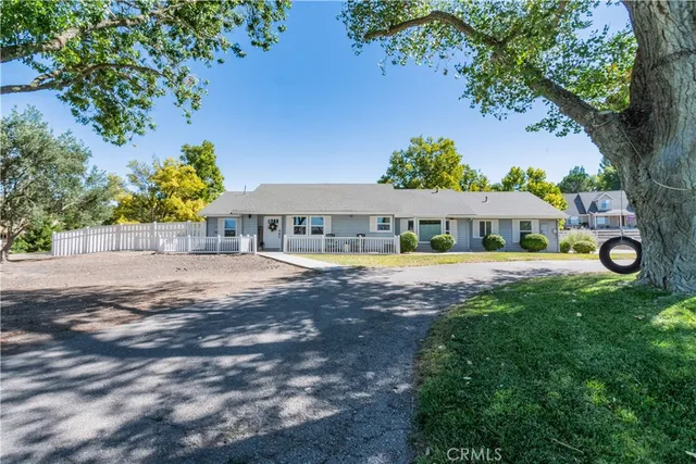 a front view of house with yard and trees around