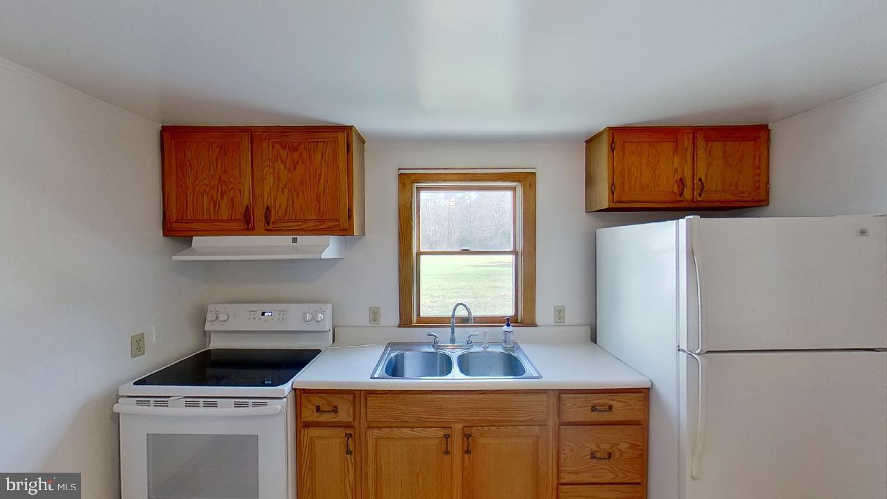 42464 Fairgrounds Road Leonardtown, MD 20650 - Photo 13 of 33 a kitchen with a stove a refrigerator and a stove top oven