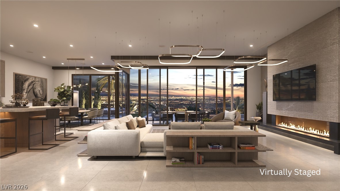 543 Overlook Rim Drive Henderson, NV 89012 - Photo 2 of 19 Floor-to-ceiling windows frame a mesmerizing city skyline, complementing this living area's contemporary fireplace and open design.