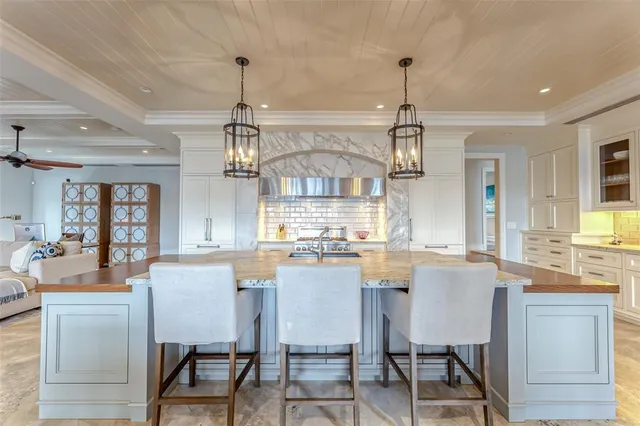 a bedroom with a large bed chandelier and a window