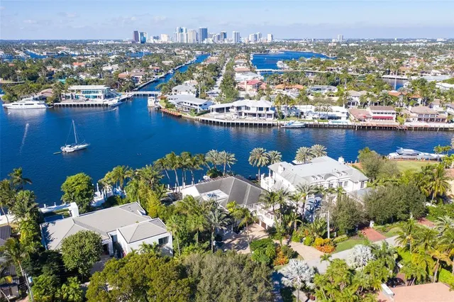 a view of a swimming pool with a lawn chairs under palm trees