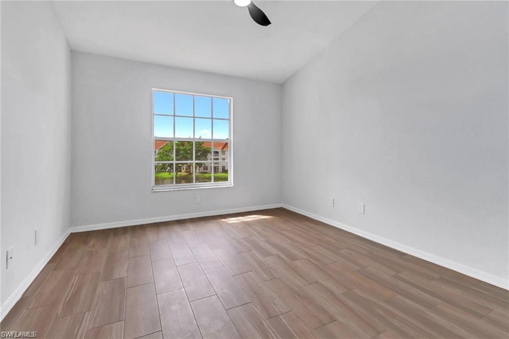 4720 St Croix Lane, Unit 135 Naples, FL 34109 - Photo 9 of 24 a view of an empty room with wooden floor and a window