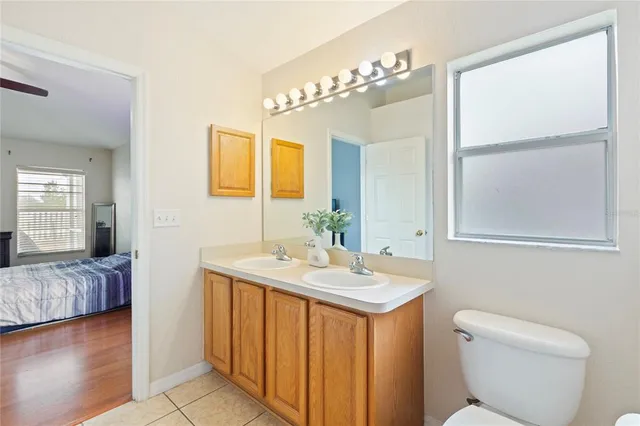 a en suite bathroom with a granite countertop sink and a mirror