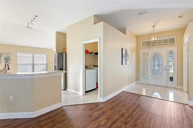 a view of a big room with wooden floor and windows