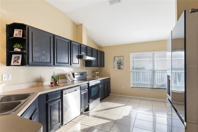a kitchen with a sink a stove and cabinets