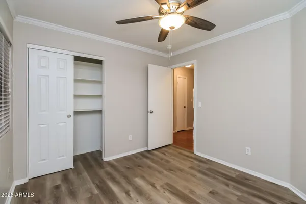 an empty room with closet and a ceiling fan