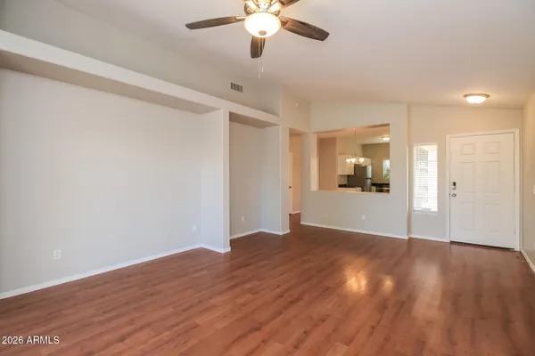a view of a big room with wooden floor and a chandelier fan