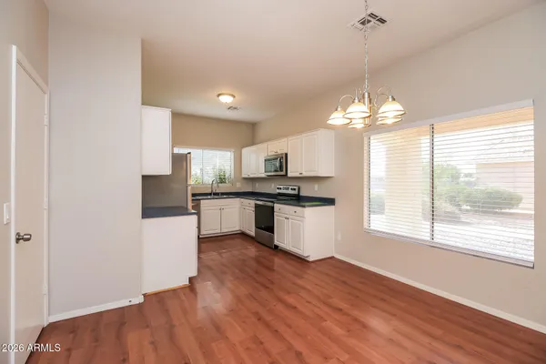 a large kitchen with kitchen island white cabinets and stainless steel appliances