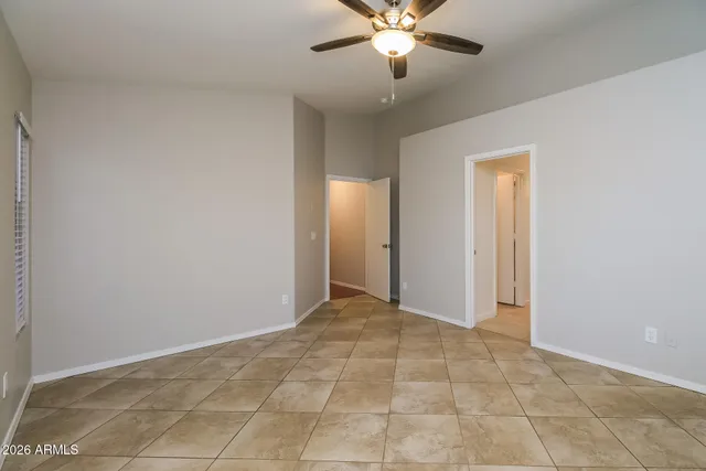 a view of an empty room with a chandelier fan