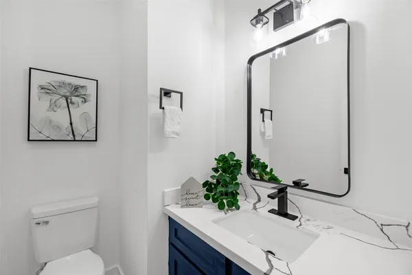 a bathroom with a sink mirror and toilet
